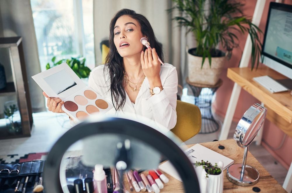 Shot of a influencer recording a makeup tutorial for her blog at home.