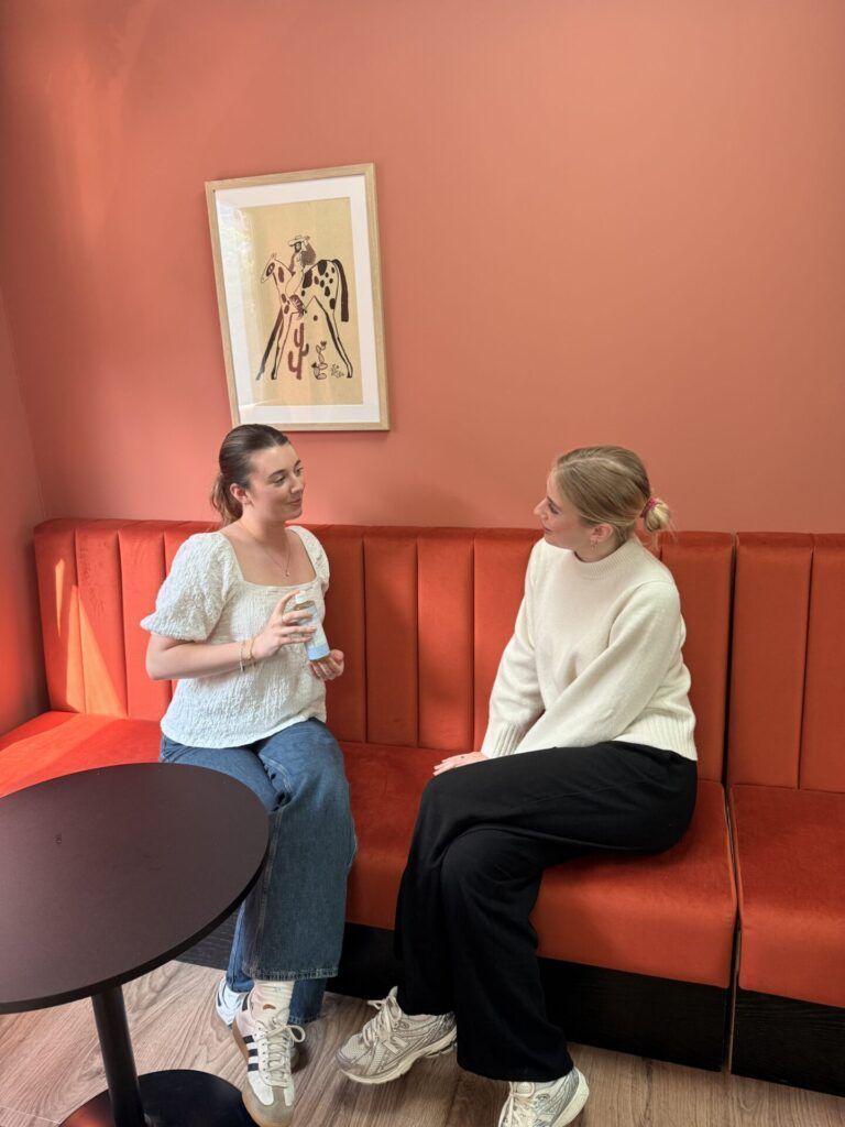 two young women sitting down talking